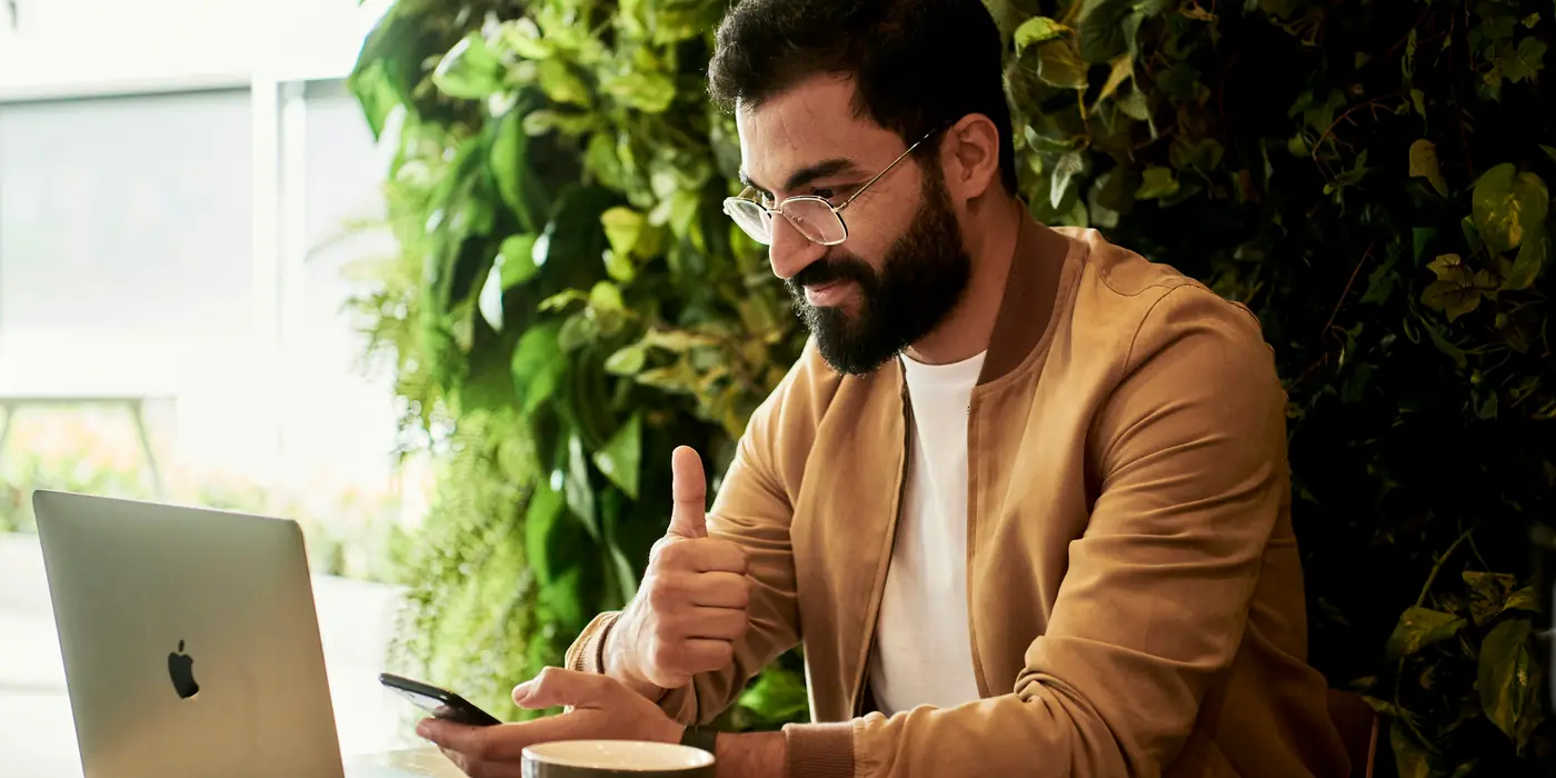 Persona trabajando con un portátil en la terraza de una cafetería